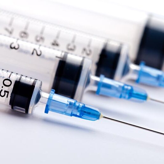 Row of medical syringes with blue lids medical syringes for clinical toxicology testing